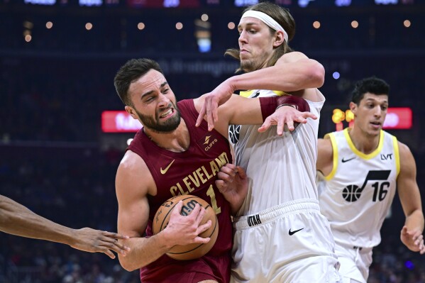 Cleveland Cavaliers guard Max Strus drives on Utah Jazz forward Kelly Olynyk during the first half of an NBA basketball game Wednesday, Dec. 20, 2023, in Cleveland. (AP Photo/David Dermer)