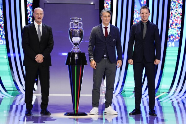 FILE - The head coaches of Hungary Marco Rossi, left, Switzerland Murat Yakin, center, and Germany Julian Nagelsmann, right, pose next to the trophy after the draw for the UEFA Euro 2024 soccer tournament finals in Hamburg, Germany, Saturday, Dec. 2, 2023. Host nation Germany may be the heavyweight in its European Championship group, but any of Scotland, Hungary or Switzerland is capable of causing an upset in Group A. (AP Photo/Martin Meissner, File)