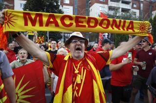 A protester dressed in the national colors attends a protest in front of the government building in Skopje, North Macedonia, on Saturday, July 2, 2022. Tens of thousands of people have gathered late on Saturday in North Macedonia's capital Skopje to protest the latest French presidency proposal on solving bilateral disputes with Bulgaria that gave directions for small Balkan country to open membership talks with the European Union. (AP Photo/Boris Grdanoski)