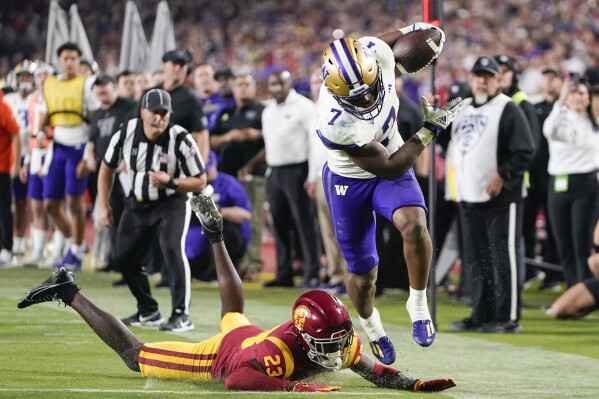 Washington running back Dillon Johnson, right, runs past Southern California cornerback Tre'Quon Fegans during the second half of an NCAA college football game Saturday, Nov. 4, 2023, in Los Angeles. (AP Photo/Ryan Sun)