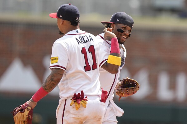 Atlanta Braves' Ronald Acuna Jr. celebrates a win against the Los Angeles Angels with teammate Orlando Arcia (11) after a baseball game, Wednesday, Aug. 2, 2023, in Atlanta. (AP Photo/Brynn Anderson)