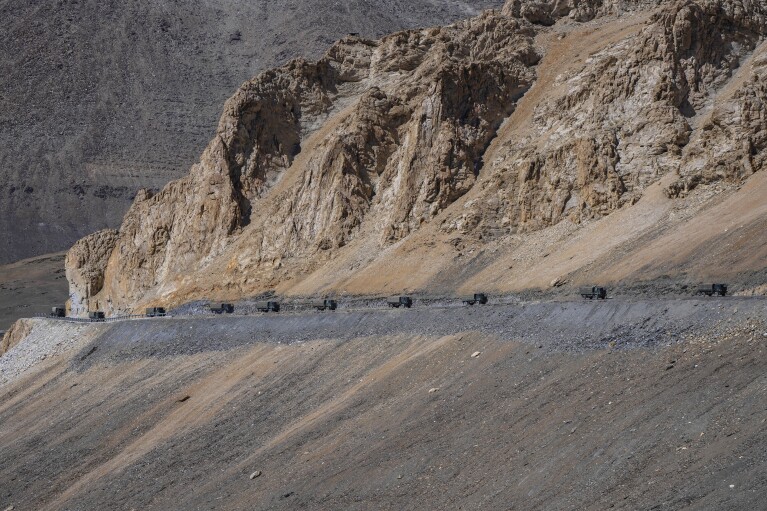 FILE- Indian army vehicles move in a convoy in the cold desert region of Ladakh, where India and China are locked in a military standoff, Sept. 18, 2022. For decades, India has focused its defense priorities on its land borders with rivals Pakistan and China. Now, as its global ambitions expand, it is beginning to flex its naval power in international waters, including a deployment in the Red Sea to help protect ships from attacks during Israel's war with Hamas. (AP Photo/Mukhtar Khan, File)