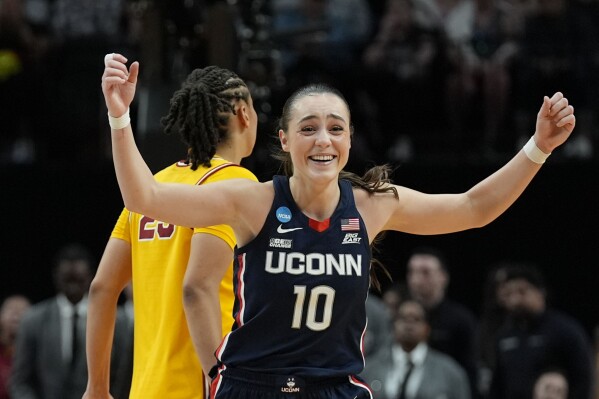 UConn guard Nika Muhl (10) cheers after an Elite Eight college basketball game against Southern California in the women's NCAA Tournament, Monday, April 1, 2024, in Portland, Ore. UConn won 80-73. (AP Photo/Jenny Kane)