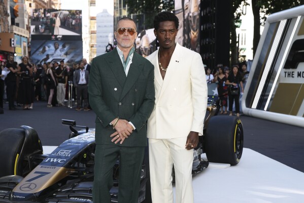 Brad Pitt, left, and Damson Idris pose for photographers upon arrival at the premiere of the film 'F1 The Movie' on Monday, June 23, 2025, in London. (Photo by Scott A Garfitt/Invision/AP)