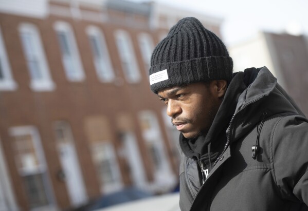 Antonio Moore, 24, of Baltimore, stands in his childhood neighborhood in east Baltimore, Monday, Feb. 26, 2024. Moore, is a successful real estate investor and entrepreneur who founded a consulting company that helps brands and nonprofits connect with urban youth. (AP Photo/Steve Ruark)