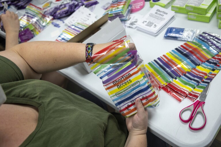 Volunteers assemble reproductive health kits during a reproductive health kit packing party held at The Community Center in Boise, Idaho, on Friday, April 12, 2024. (AP Photo/Kyle Green)
