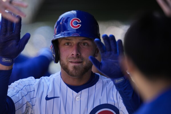 Chicago Cubs' Michael Busch celebrates in the dugout after hitting a home run during the third inning of a baseball game against the Los Angeles Dodgers, Friday, April 5, 2024, in Chicago. (AP Photo/Erin Hooley)