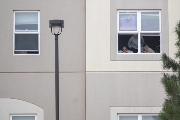 Students look outside their dorm window in the Village at Alpine Valley housing, Friday, Feb. 16, 2024, as police investigate a shooting on the University of Colorado Colorado Springs campus in Colorado Springs, Colo. (Christian Murdock/The Gazette via 麻豆传媒app)
