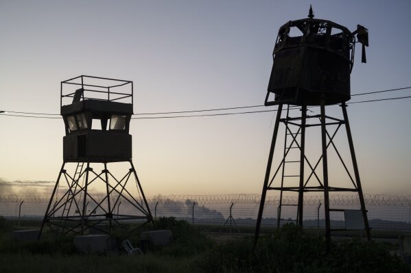 Old observation towers stand near a fence as smoke rises after an explosion in the Gaza Strip, seen from Kibbutz Nahal Oz, Israel, Wednesday, Feb. 28, 2024. (AP Photo/Leo Correa)