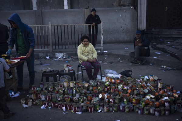 Palestinians sell canning in a street market in Rafah, Gaza Strip, Tuesday, Feb. 20, 2024. An estimated 1.5 million Palestinians displaced by the war took refuge in Rafahor, which is likely Israel's next focus in its war against Hamas. (AP Photo/Fatima Shbair)