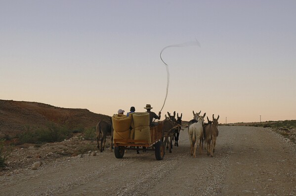A donkey-drawn cart carries people from the Richtersveld area in the North Western Cape Provice, South Africa, March 2005 where they live as they await the outcome of a lands claim action in nearby Alexandra Bay. (AP Photo/Mujahid Safodien, File)