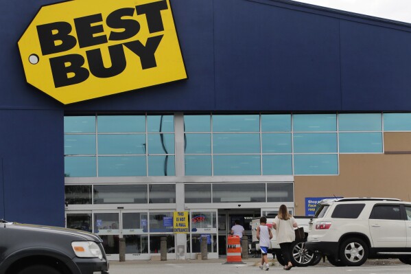 FILE - A woman walks with a boy to the Best Buy store at the Mall of New Hampshire, Tuesday, Aug. 4, 2020, in Manchester, N.H. Best Buy sales and profits slid in the second quarter, Tuesday, Aug. 29, 2023, as the nation's largest consumer electronics chain continues to wrestle with a pullback in spending on gadgets after Americans splurged during the pandemic.(AP Photo/Charles Krupa, File)