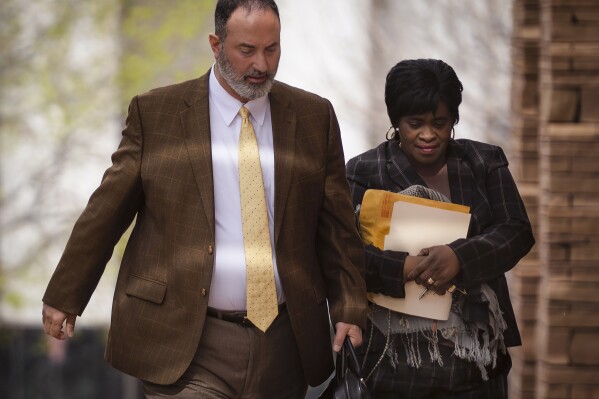 Sheryl Williams Stapleton, a former state House majority leader and APS employee, right, walks with her attorney Ahmad Assed, left, to make her first appearance in U.S. District Court in Albuquerque, N.M., on Tuesday, April 9, 2024. (Chancey Bush/The Albuquerque Journal via AP)