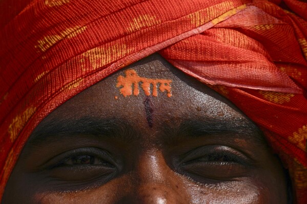 A Hindu devotee has the words Sri Ram' written on his forehead as he watches in Hyderabad, India, a live telecast of inauguration of a temple dedicated to the Hindu Lord Ram in northern Ayodhya town, Monday, Jan. 22, 2024. Indian Prime Minister Narendra Modi on Monday opened a controversial Hindu temple built on the ruins of a historic mosque in the holy city of Ayodhya in a grand event that is expected to galvanize Hindu voters in upcoming elections. (AP Photo/Mahesh Kumar A.)
