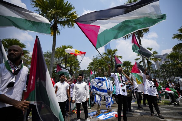 Malaysian Muslim wave Palestinian flags during a rally to show support to the Palestinian people, outside the national mosque in Kuala Lumpur, Malaysia, Friday, Oct. 13, 2023. (AP Photo/Vincent Thian)