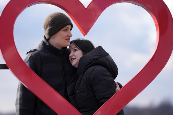 Mariia Vyhivska, from Ukraine, left, and Iurii Kurochkin, from Russia, pose with a heart-shaped sign on the banks of the Ada Ciganlija Lake, in Belgrade, Serbia, Sunday, Feb. 5, 2023. Vyhivska and Kurochkin fell in love before Russia invaded Ukraine, while playing an online video game. To get together, they had to leave their homes and defy hatred generated by war. An estimated 200,000 Russians and some 20,000 Ukrainians have come to Serbia in the past year. (AP Photo/Darko Vojinovic)