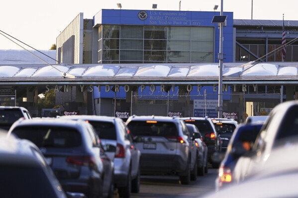 Vehicles wait in line to cross the border into the United States at the San Ysidro Port of Entry, Tuesday, March 18, 2025, in Tijuana, Mexico. (AP Photo/Gregory Bull, File)