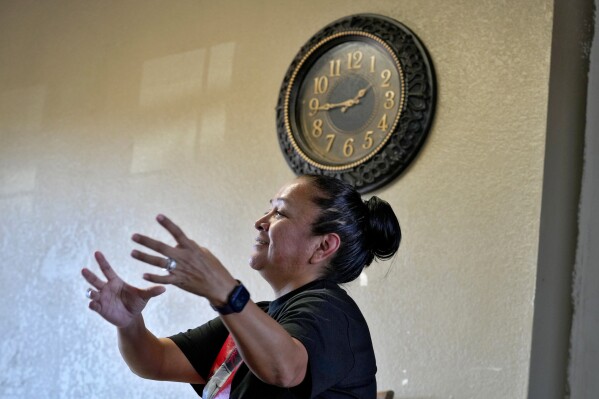 Melissa Blackhair speaks of daylight savings time, Monday, March 4, 2024, from her home in Tuba City, Ariz. Blackhair lives along a stretch of highway that is the de facto border between the Navajo and Hopi Indian reservations and two time zones. Mind-bending time calculations is what people in the largest Native American reservation in the U.S. have to endure every March through November. The Navajo Nation, which stretches into Utah and New Mexico, will reset clocks for one hour later despite the rest of Arizona remaining on standard time. (AP Photo/Matt York)