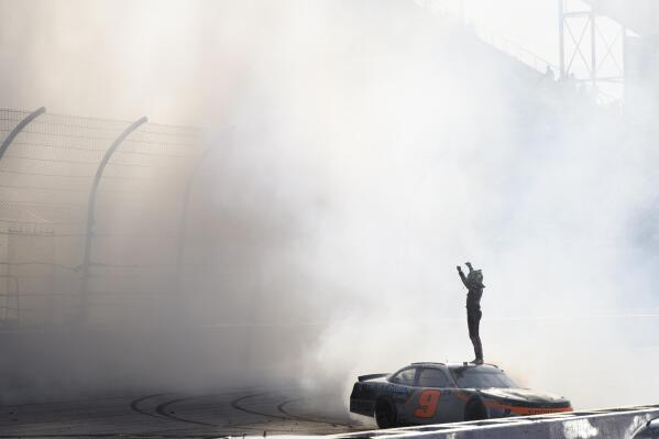 After a burnout on the track, Noah Gragson celebrates winning a NASCAR Xfinity Series auto race Saturday, Sept. 4, 2021, in Darlington, S.C. (AP Photo/John Amis)
