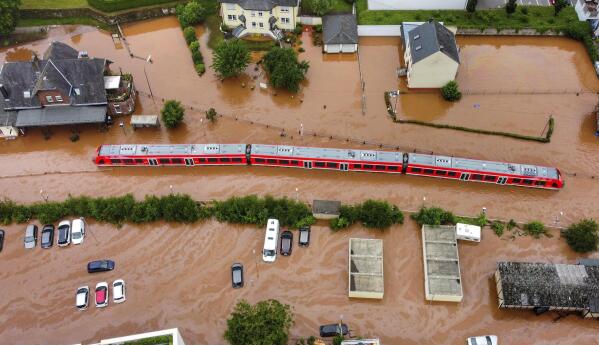 FILE - In this Thursday, July 15, 2021, 2021 file photo, a regional train in the flood waters at the local station in Kordel, Germany, after it was flooded by the high waters of the Kyll river. Scientists say global warming makes the kind of extreme rainfall that caused deadly flash floods in western Europe last month more likely, though it remains unclear exactly how much. (Sebastian Schmitt/dpa via AP, File)