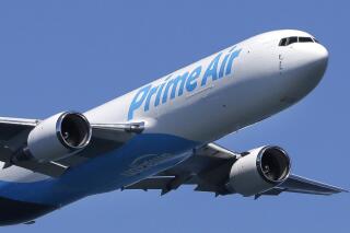 FILE - In this Friday, Aug. 5, 2016, file photo, a Boeing 767 with an Amazon.com "Prime Air" livery flies over Lake Washington, as part of the Boeing Seafair Air Show. Amazon said Wednesday, June 30, 2021, that its carbon footprint grew 19% last year as it rushed to deliver a surge of online orders during the pandemic. (AP Photo/Ted S. Warren, File)