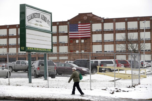 FILE - A man walks past the Remington Arms Company, Jan. 17, 2013, in Ilion, N.Y. The gun factory in upstate New York with a history stretching back to the 19th century is scheduled to close in March 2024, according to a letter from the company to union officials on Thursday, Nov. 30, 2023. (AP Photo/Mike Groll, File)