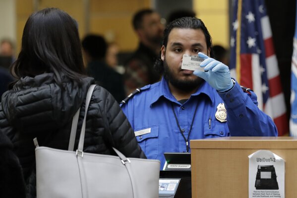 
              A TSA worker checks an identification card, Friday, Jan. 25, 2019, at Seattle-Tacoma International Airport in Seattle. Yielding to mounting pressure and growing disruption, President Donald Trump and congressional leaders on Friday reached a short-term deal to reopen the government for three weeks while negotiations continue over the president's demands for money to build his long-promised wall at the U.S.-Mexico border. (AP Photo/Ted S. Warren)
            