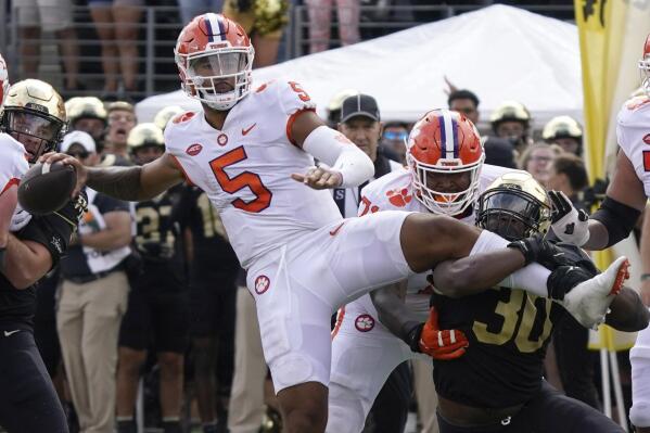 Clemson quarterback DJ Uiagalelei (5) looks to pass as Wake Forest defensive lineman Jasheen Davis (30) tries to tackle him during the second half of an NCAA college football game in Winston-Salem, N.C., Saturday, Sept. 24, 2022. (AP Photo/Chuck Burton)
