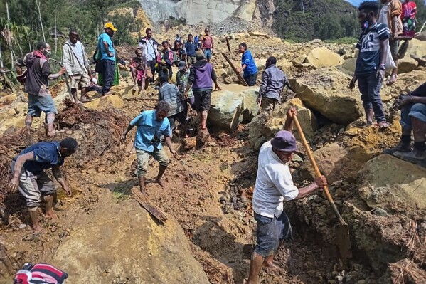 Villagers search through a landslide in Yambali, in the Highlands of Papua New Guinea, Sunday, May 26, 2024. The International Organization for Migration feared Sunday the death toll from a massive landslide is much worse than what authorities initially estimated. (Mohamud Omer/International Organization for Migration via AP)