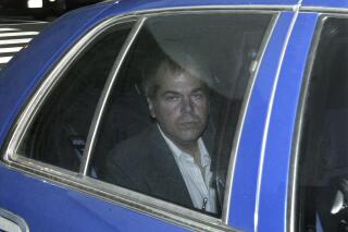FILE - In this Nov. 18, 2003, file photo, John Hinckley Jr. arrives at U.S. District Court in Washington. A court hearing has been set for Aug. 30, 2021, regarding whether Hinckley, the man who tried to assassinate President Ronald Reagan, can live without restrictions in the home he shares with his mother and brother in a gated community in Virginia. (AP Photo/Evan Vucci, File)