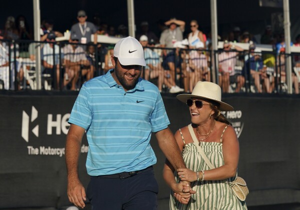 Scottie Scheffler celebrates with his wife after winning the Hero World Challenge PGA Tour at the Albany Golf Club, in New Providence, Bahamas, Sunday, Dec. 3, 2023. (AP Photo/Fernando Llano)