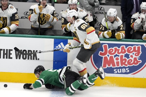 Dallas Stars center Wyatt Johnston, left, falls to the ice attempting to control the puck under pressure from Vegas Golden Knights right wing Mark Stone (61) in the third period in Game 1 of an NHL hockey Stanley Cup first-round playoff series in Dallas, Monday, April 22, 2024. (AP Photo/Tony Gutierrez)