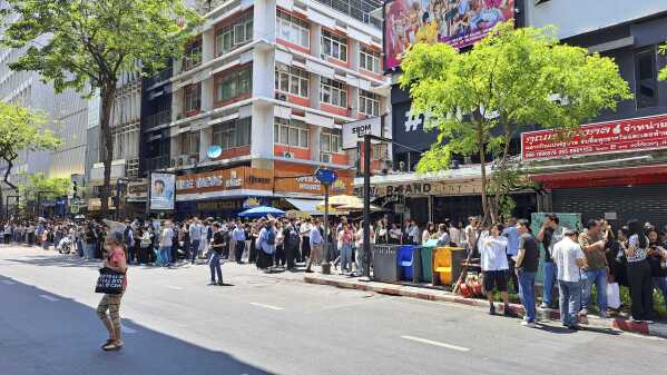 People who evacuated from buildings following earthquake in Bangkok, Thailand, Friday, March 28, 2025. (AP Photo/Chutima Lalit)