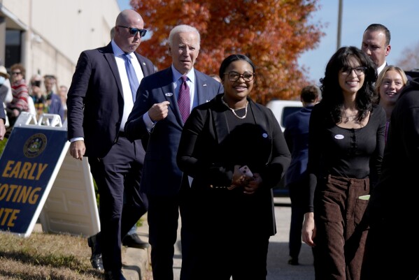 President Joe Biden, second left, departs a polling station alongside first-time voters after casting his early-voting ballot for the 2024 general elections, Monday, Oct. 28, 2024, in New Castle, Del. (AP Photo/Manuel Balce Ceneta)