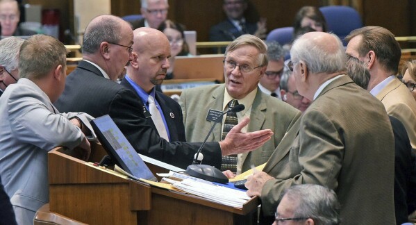 FILE- North Dakota House Majority Leader Rep. Chet Pollert, R-Carrington, second from left, gestures toward House Speaker Rep. Kim Koppelman, R-West Fargo, far right, prior to the start of the floor session and votes on whether to override three vetoes by Gov. Doug Burgum, which includes a bill restricting transgender girls from participating in public elementary and secondary school sports, Thursday, April 22, 2021, at the state Capitol in Bismarck, N.D. U.S. states with laws restricting what bathrooms transgender kids can use in public schools are wrestling with how those laws will be enforced. At least 10 states have enacted such laws and transgender, nonbinary and gender-noncomforming people expect states to rely on what they call vigilante enforcement by private individuals. (Tom Stromme/The Bismarck Tribune via AP, File0