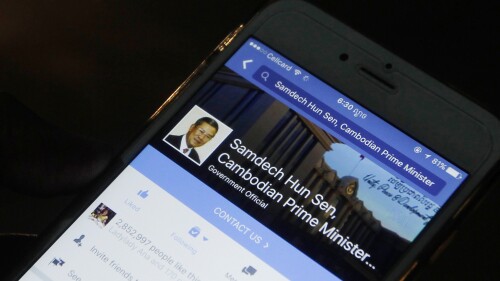 DATEI – Ein Mann schaut sich am 1. März 2016 auf seinem Mobiltelefon auf dem Bürgersteig in der Innenstadt von Phnom Penh, Kambodscha, die Facebook-Seite des kambodschanischen Premierministers Hun Sen an. Hun Sen reaktivierte am Donnerstag, dem 20. Juli 2023, sein Facebook-Konto, nur drei Wochen nachdem er angekündigt hatte, dass er den Social-Media-Riesen aufgeben und stattdessen auf Telegram posten würde, einer beliebten Messaging-App, die auch als Blogging-Tool dient.  (AP-Foto/Heng Sinith, Datei)