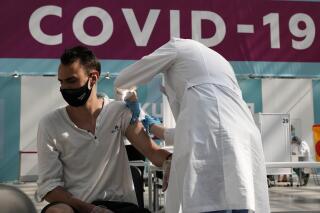 FILE - In this July 12, 2021, file photo, a medical worker administers a shot of Russia's Sputnik V coronavirus vaccine at a vaccination center in Gostinny Dvor, a huge exhibition place in Moscow, Russia. In Russia, it's common to get an antibody test and share the results. The tests are cheap, widely available and actively marketed by private clinics nationwide, and their use appears to be a factor in the country's low vaccination rate even as daily deaths and infections are rising again. (AP Photo/Pavel Golovkin, File)