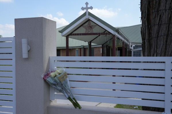 FILE - Flowers sit on a fence outside the Christ the Good Shepherd church in suburban Wakely in western Sydney, Australia, on April 16, 2024. An Australian judge said Tuesday, May 14, 2024, it would be unreasonable for the country's internet safety watchdog to require social platform X to hide video of a bishop being stabbed in a Sydney church from all of its users globally, as he explained his decision to lift a court order that had required X to hide the video of the attack. (AP Photo/Mark Baker, File)