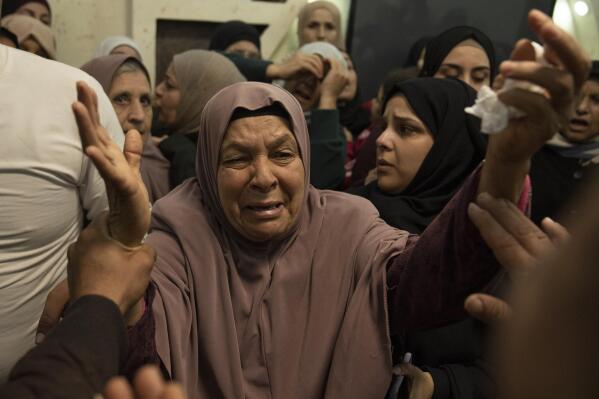 A mourner cries after taking the last look at the body of Atta Shalabi at the family house during his funeral in the West Bank town of Qabatiya, south of Jenin, Thursday, Dec. 8, 2022. Israeli forces killed Palestinians Atta Shalabi, Tarek al-Damj, and Sedki Zakarneh, during an early Thursday raid in the occupied West Bank, the Palestinian Health Ministry said, the latest violence to shake the region after months of unrest. (AP Photo/Nasser Nasser)