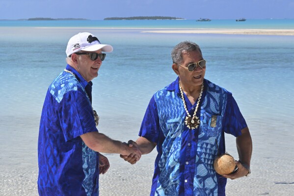 Australia's Prime Minister Anthony Albanese, left, and Tuvalu's Prime Minister Kausea shake hands on One Foot Island after attending the Leaders' Retreat during the Pacific Islands Forum in Aitutaki, Cook Islands, Thursday, Nov. 9, 2023. Australia on Friday offered the island nation of Tuvalu a lifeline to help residents escape the rising seas and increased storms that climate change is bringing. (Mick Tsikas/AAP Image via AP)