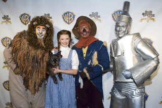 FILE - Costumed "Wizard of Oz" characters attend the "Wizard of Oz" 70th Anniversary Emerald Gala on Sept. 24, 2009, in New York. New Line Cinema is making a new adaptation of “The Wonderful Wizard of Oz,” the L. Frank Baum children’s novel, with Nicole Kassell, the visual architect of “Watchmen,” set to direct. (AP Photo/Charles Sykes, File)