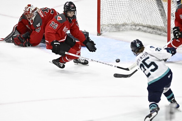 Ottawa's Emerance Maschmeyer (38) watches as Ottawa's Emily Clark (26) is unable to defend against a shot by New York's Alex Carpenter (25) who scores to tie a PWHL hockey game in the third period in Ottawa, Ontario, Sunday, Feb. 4, 2024. (Justin Tang/The Canadian Press via AP)