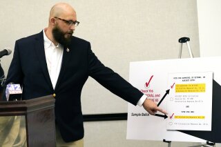 Jonathan C. Brown, 35, a Hattiesburg businessman and former U.S. Air Force staff sergeant, explains how to vote for Initiative 65, a strictly regulated medical marijuana program, that is on the general election ballot this November, during a Wednesday, Oct. 22, 2020 news conference in Jackson, Miss. (AP Photo/Rogelio V. Solis)