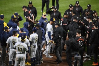 Members of the Baltimore Orioles and Milwaukee Brewers gather at the home plate area after the benches cleared during the sixth inning of a baseball game Friday, April 12, 2024, in Baltimore. (AP Photo/Nick Wass)