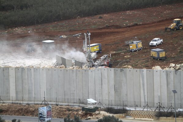 
              An Israeli military digger works on the Lebanese-Israeli border next to a wall that was built by Israel in the southern village of Kafr Kila, Lebanon, Tuesday, Dec. 4, 2018. The Israeli military launched an operation on Tuesday to "expose and thwart" tunnels it says were built by the Hezbollah militant group that stretch from Lebanon into northern Israel. (AP Photo/Mohammed Zaatari)
            
