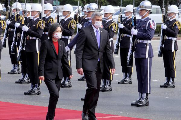 Taiwan's President Tsai Ing-wen, left, and Paraguay's President Mario Abdo Benitez walk past an honor guard at the Presidential House in Taipei, Taiwan, Thursday, Feb. 16, 2023. The outgoing president of Paraguay, whose country is one of Taiwan's few remaining diplomatic allies, spoke of his admiration of the island's democracy Thursday while on a state visit. (AP Photo/Johnson Lai)