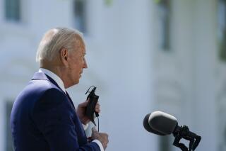 President Joe Biden removes his face mask to speak about COVID-19, on the North Lawn of the White House, Tuesday, April 27, 2021, in Washington. (AP Photo/Evan Vucci)