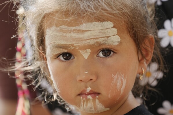 Elouera Dephoff, 2, has traditional paint adornments on her face while attending an Indigenous Australians protest during Australia Day in Sydney, Friday, Jan. 26, 2024. Thousands of Australians protest on the anniversary of British colonization of their country amid fierce debate over whether the increasingly polarizing national holiday dubbed 'Australia Day' should be moved to another date. (AP Photo/Rick Rycroft)