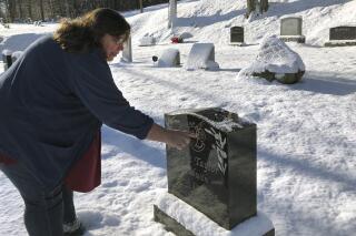 FILE - Deb Walker, of Chester, Vt., visits the grave of her daughter Brooke Goodwin, Thursday, Dec. 9, 2021, in Chester. Goodwin, 23, died in March of 2021 of a fatal overdose of the powerful opioid fentanyl and xylazine. Government data released on Wednesday, Nov. 16, 2022, suggests U.S. overdose deaths have stopped rising in 2022 — a hopeful sign of at least a plateau in a public health crisis that has been worsening for decades. (AP Photo/Lisa Rathke, File)