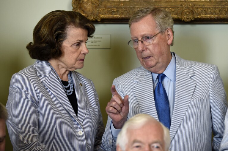 FILE - U.S. Sen. Dianne Feinstein, D-Calif., talks with Senate Majority Leader Mitch McConnell, of Ky., on Capitol Hill in Washington, Thursday, June 11, 2015, before a group photo of senators for National Seersucker Day. (AP Photo/Susan Walsh, File)